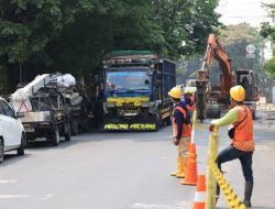 Petugas mengatur arus kendaraan di sekitar lokasi perbaikan Jalan Raya M. Toha, Kota Tangerang. Pengendara diimbau berhati-hati dan menyesuaikan rute perjalanan selama proyek berlangsung.