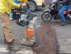 Petugas Dinas PUPR Kota Tangerang melakukan pemadatan material tambal jalan sebagai bagian dari penanganan cepat terhadap ruas jalan yang mengalami kerusakan.