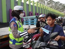 Personel kepolisian membagikan masker kepada masyarakat dalam upaya mengantisipasi paparan abu vulkanik Gunung Anak Krakatau di wilayah Tangerang.